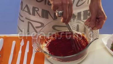 用手在玻璃碗中缓慢搅拌暗红色物质